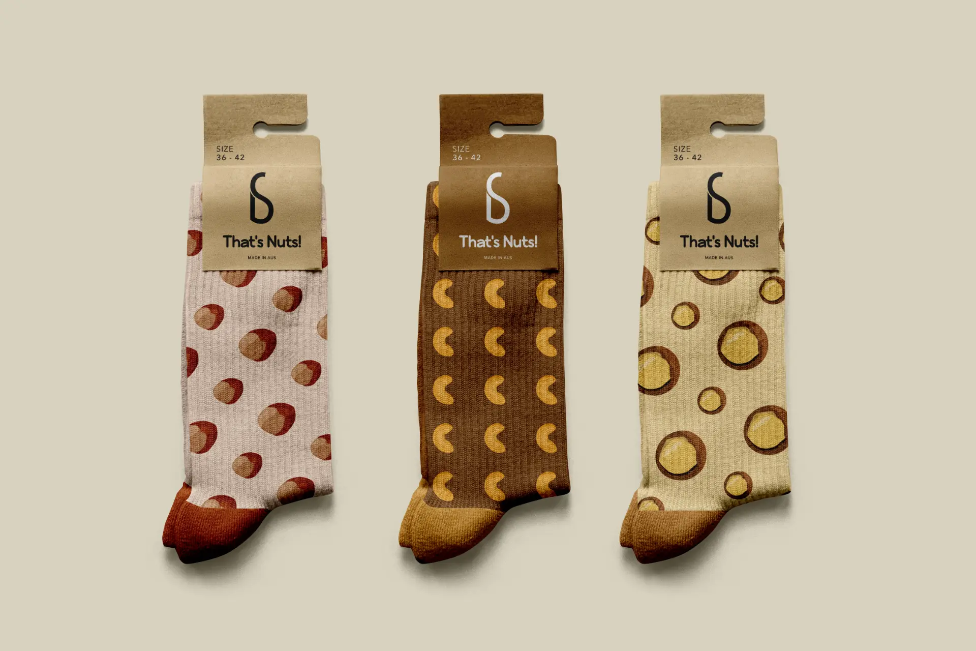 Three pairs of That's Nuts! socks with hazelnut, cashew and macadamia patterns in kraft packaging